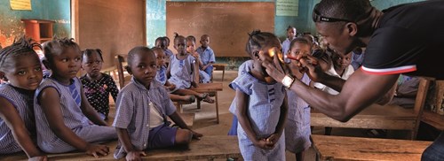 Classroom of girls waits for an eye exam